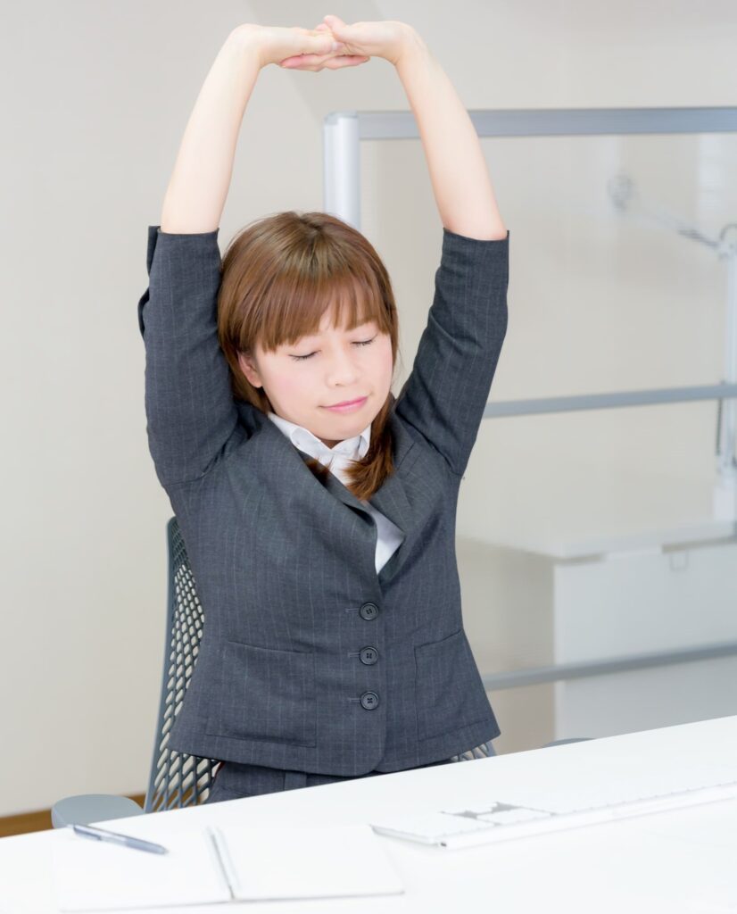 仕事で伸びをしている女性